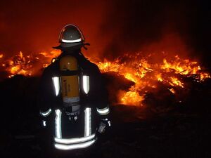 Feuerwehrmann beim Brand einer Mülldeponie. Bild: Wikimedia Commons